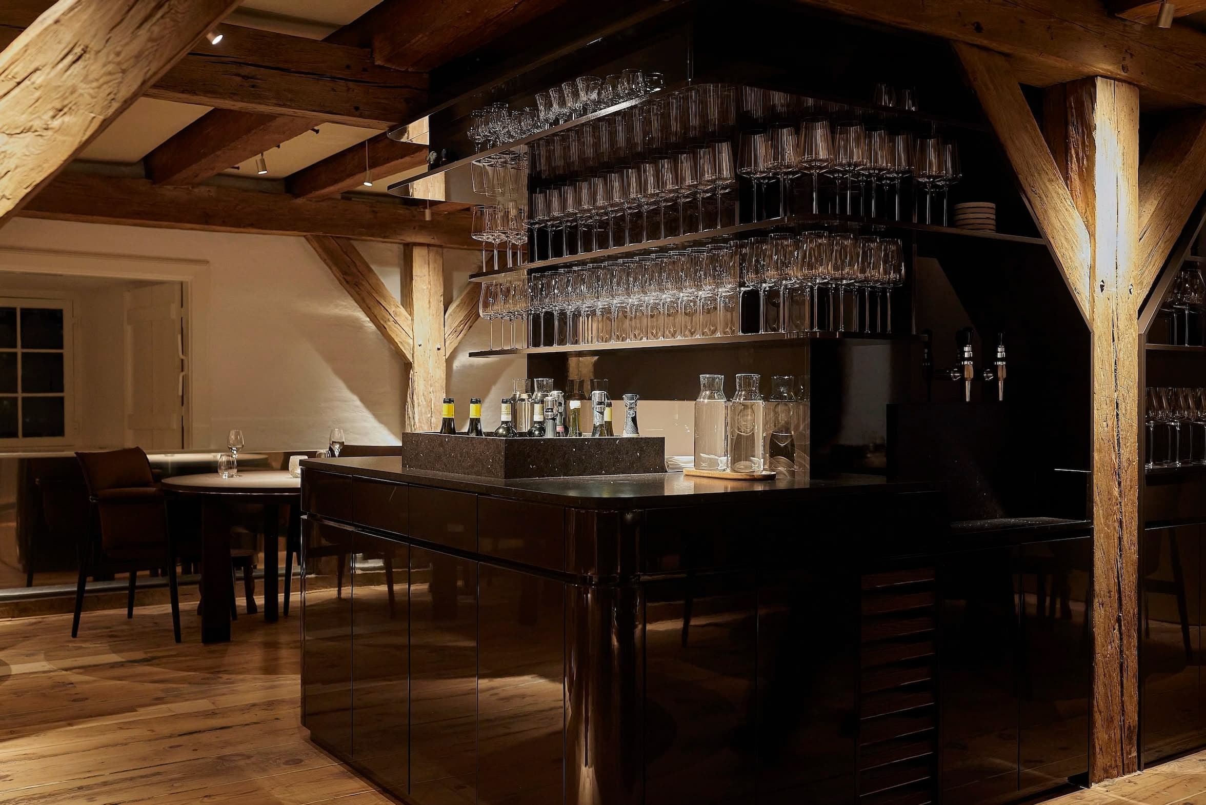 Wine glasses and bottles on the shelves behind the bar at Aure
